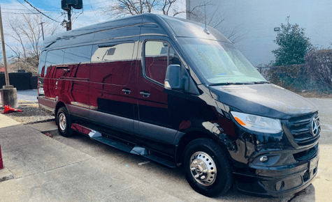 a high-roof black Mercedes-Benz Sprinter van, used for executive group travel and VIP airport transfers